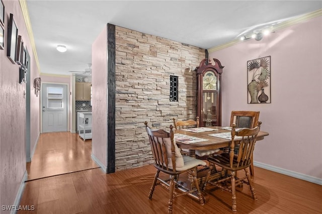 dining room with light wood-type flooring and crown molding