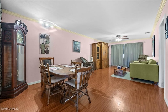 dining area featuring ceiling fan, hardwood / wood-style floors, and crown molding