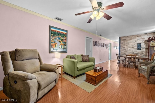 living room featuring wood-type flooring, ornamental molding, and ceiling fan