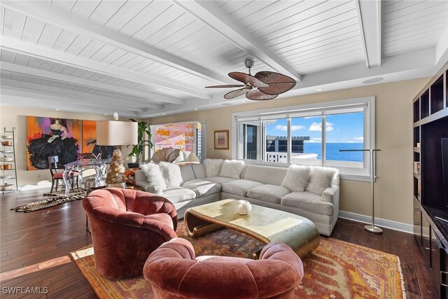 living room with ceiling fan, dark hardwood / wood-style flooring, a water view, and beam ceiling