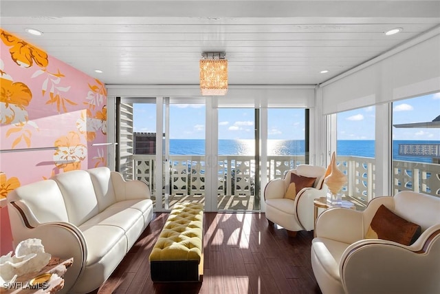 sunroom / solarium featuring wooden ceiling and a water view