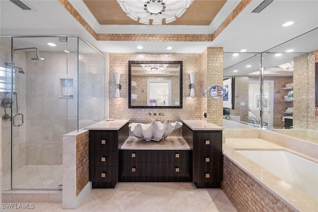 bathroom with a raised ceiling, breakfast area, ornamental molding, independent shower and bath, and vanity