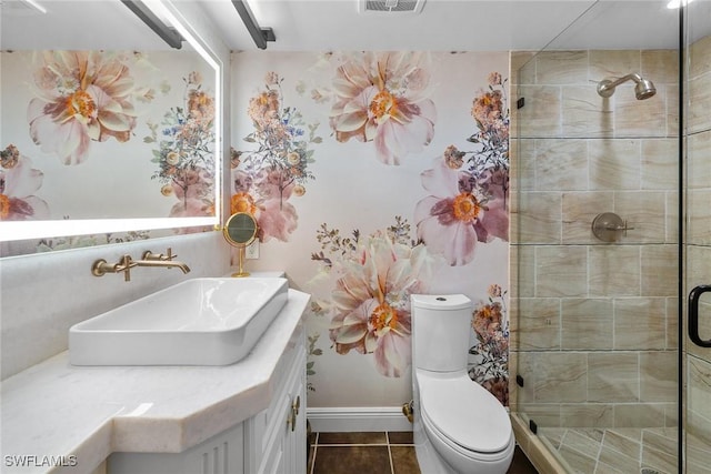 bathroom with toilet, vanity, tile patterned flooring, and a shower with shower door