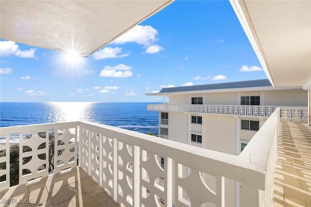 balcony featuring a water view and a view of the beach