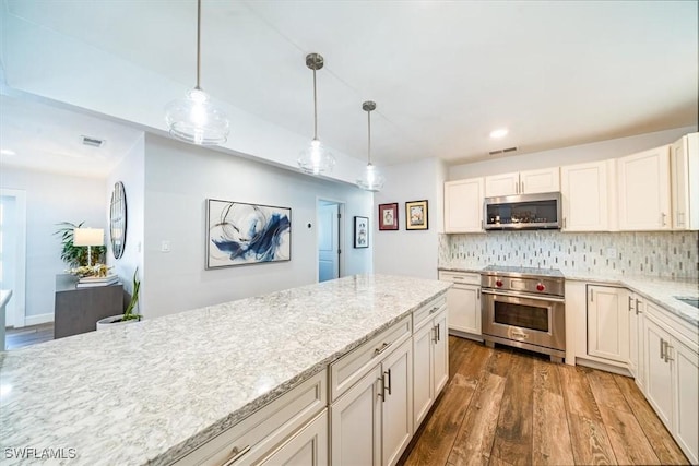 kitchen featuring pendant lighting, white cabinets, appliances with stainless steel finishes, dark hardwood / wood-style flooring, and tasteful backsplash