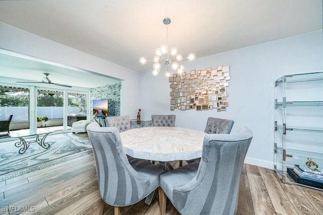 dining area featuring light hardwood / wood-style floors and ceiling fan with notable chandelier