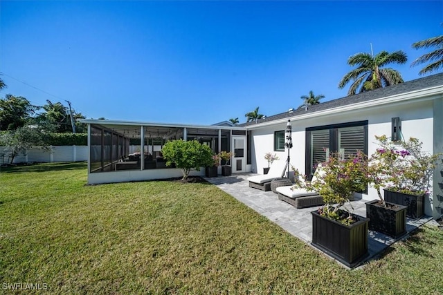 back of house with a patio area, a sunroom, and a lawn