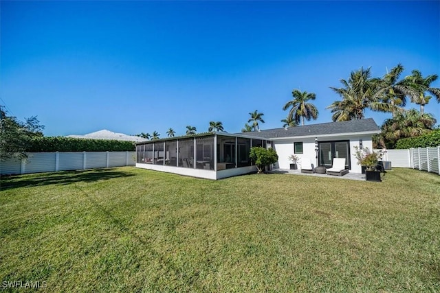 back of house featuring a sunroom, a patio, a yard, and central AC