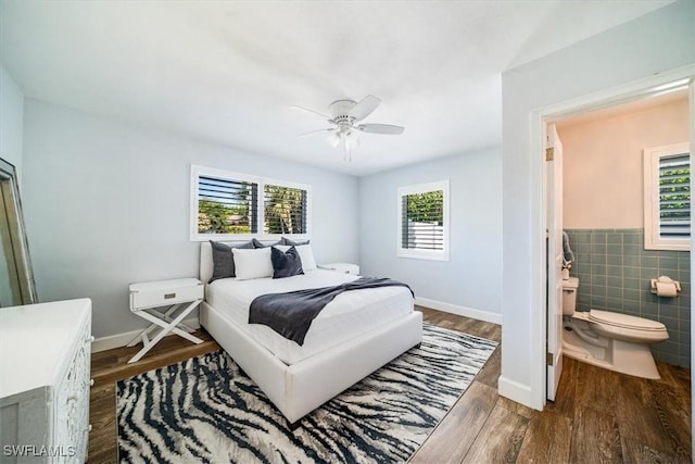 bedroom featuring ceiling fan, tile walls, and wood-type flooring