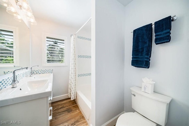 full bathroom with toilet, shower / bathtub combination with curtain, hardwood / wood-style floors, and vanity