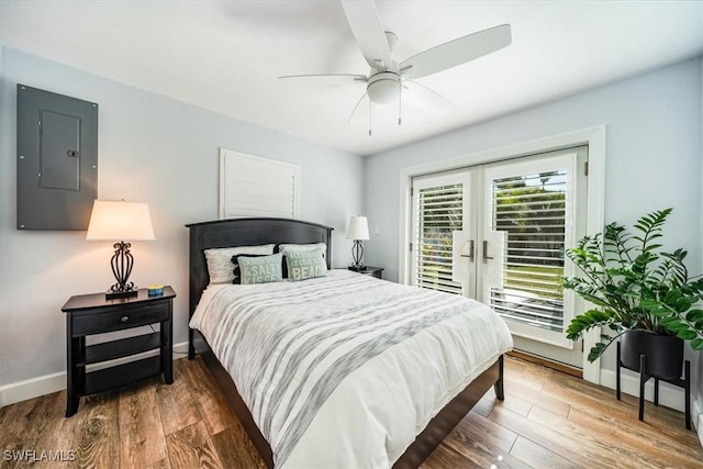 bedroom with ceiling fan, hardwood / wood-style floors, electric panel, and access to outside