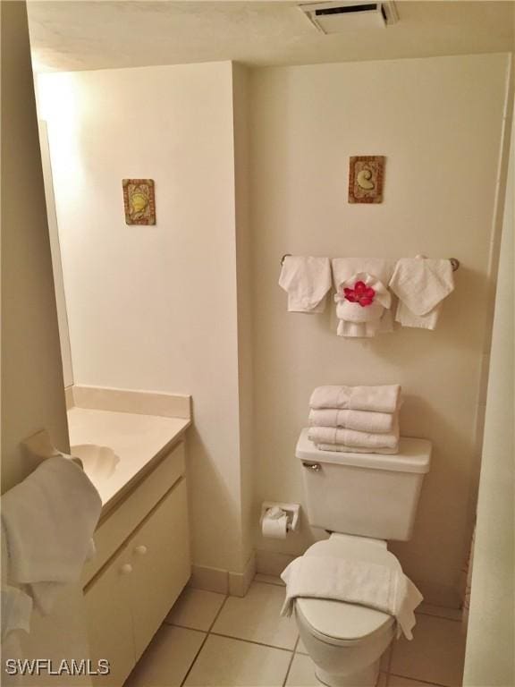 bathroom with toilet, tile patterned floors, and vanity