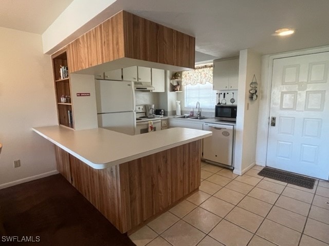 kitchen with white appliances, white cabinetry, sink, kitchen peninsula, and light tile patterned floors