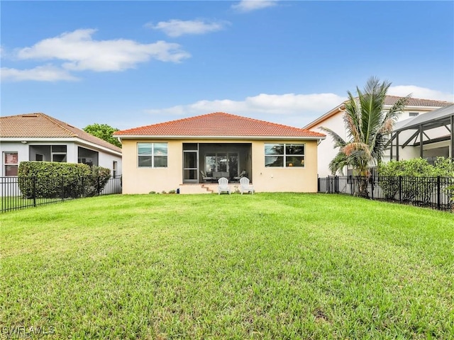 rear view of property with a lawn and a lanai