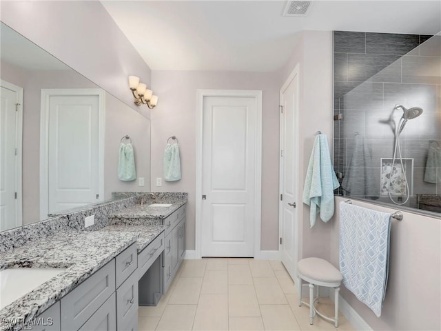 bathroom featuring tiled shower, tile patterned floors, and vanity