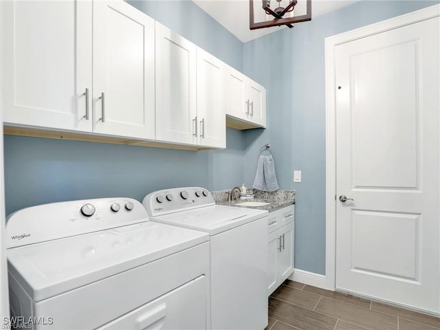 laundry area featuring sink, separate washer and dryer, and cabinets