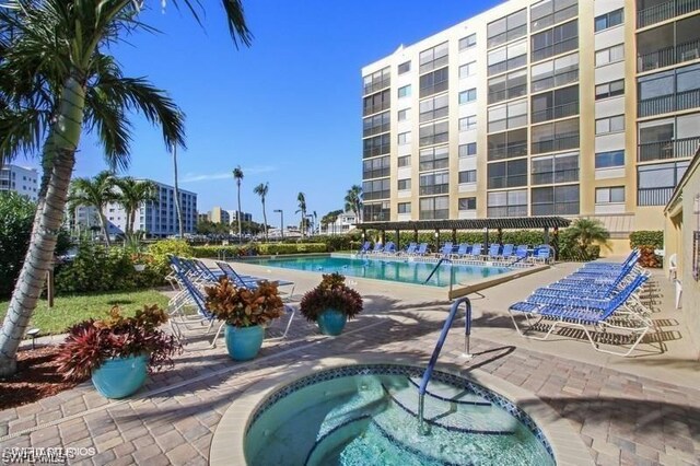 view of pool featuring a community hot tub and a patio area