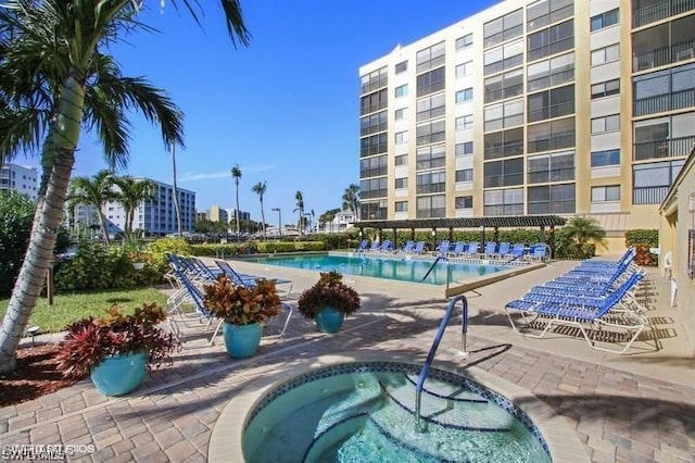 view of swimming pool with a patio and a community hot tub