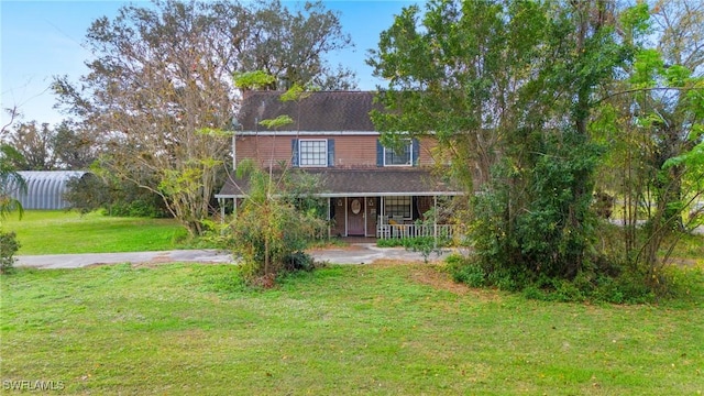 view of front facade with a front yard and covered porch