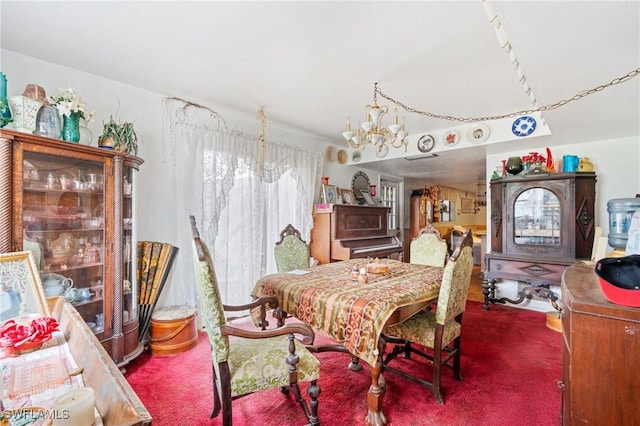 dining room featuring carpet and a chandelier