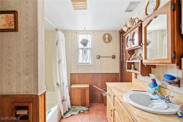 bathroom with tile patterned floors, vanity, shower / tub combo, and wooden walls