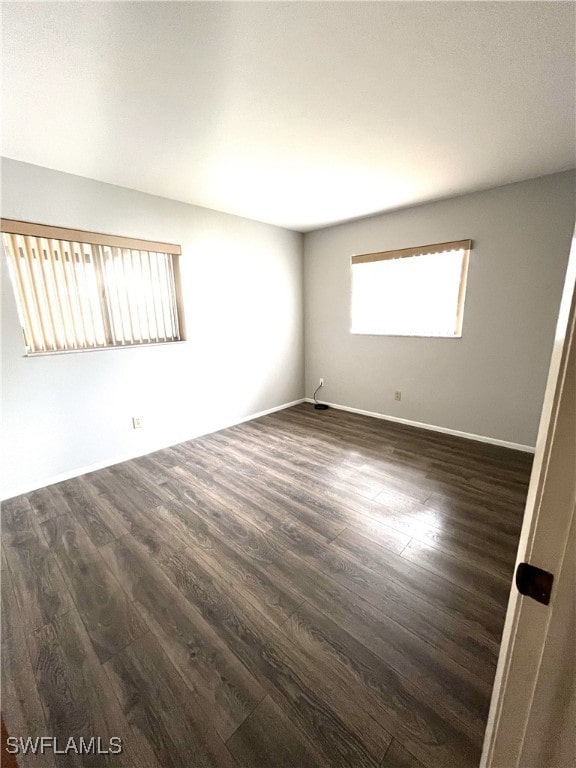 unfurnished room with dark wood-type flooring