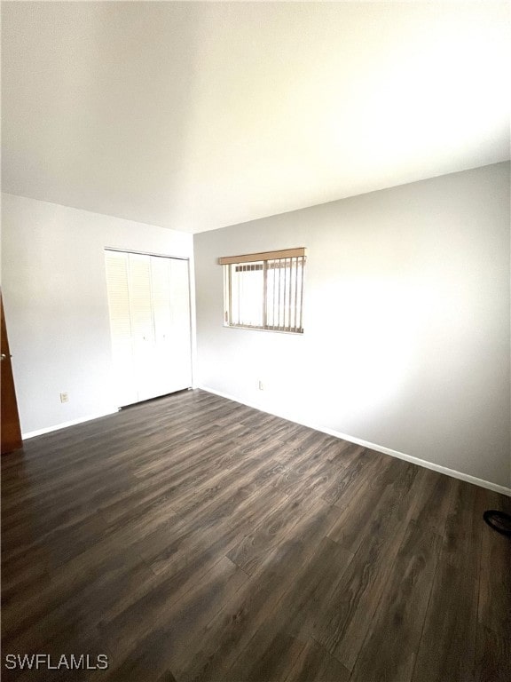 empty room with dark hardwood / wood-style flooring