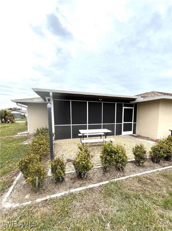 view of home's exterior featuring a lawn and a sunroom