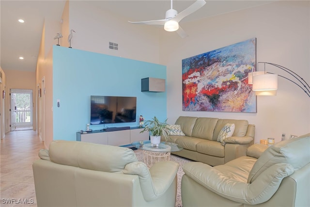 tiled living room featuring a towering ceiling and ceiling fan