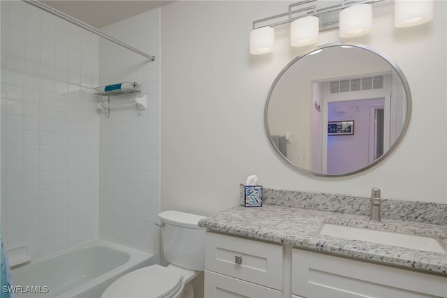 full bathroom with vanity, tiled shower / bath combo, and toilet