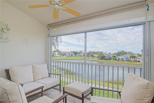 sunroom with a water view and ceiling fan