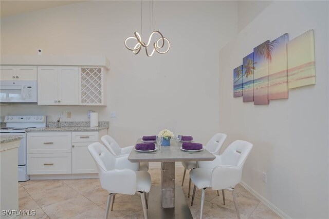 tiled dining room featuring an inviting chandelier