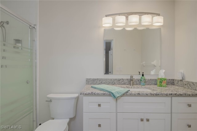 bathroom with vanity, walk in shower, and toilet