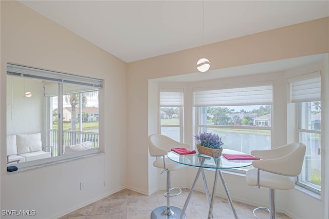 tiled dining room with breakfast area and lofted ceiling