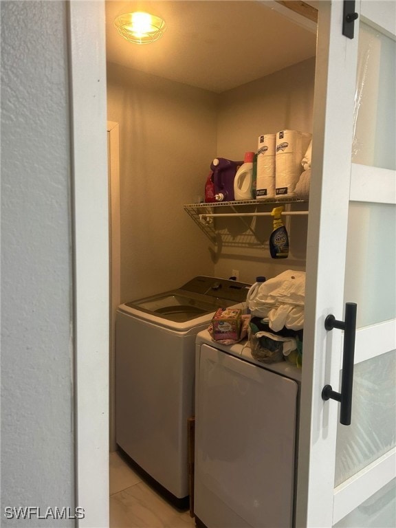 laundry area featuring separate washer and dryer and light tile patterned flooring