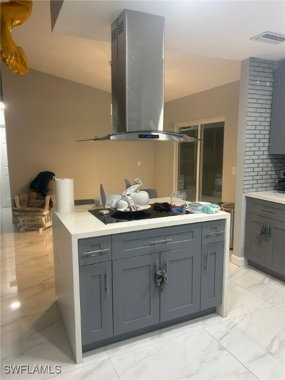 kitchen with black electric stovetop, island exhaust hood, and gray cabinets