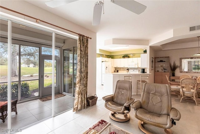 tiled living room with ceiling fan