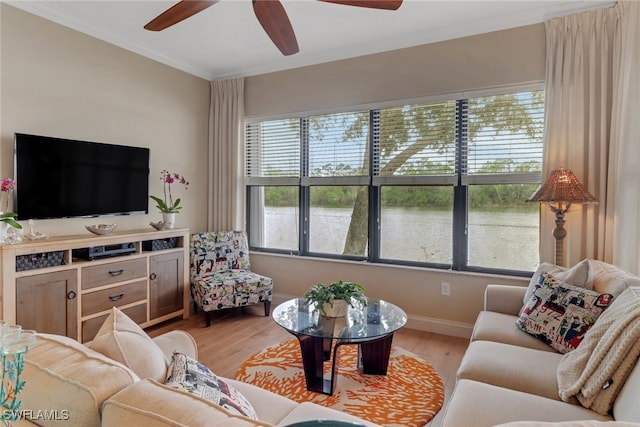 living area with ceiling fan, light wood finished floors, baseboards, and crown molding