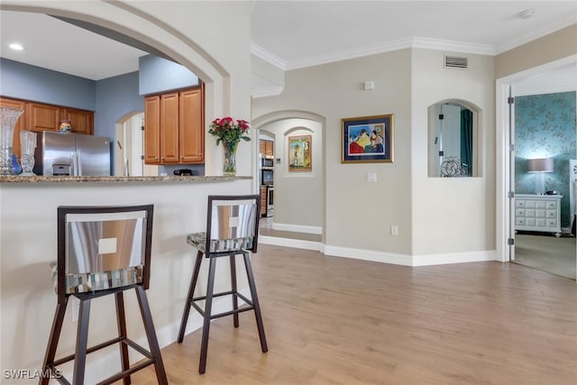 1296 Verde Dr Unit 3, Naples, FL 34105 - kitchen featuring stainless steel fridge with ice dispenser, brown cabinetry, light wood-style floors, crown molding, and baseboards