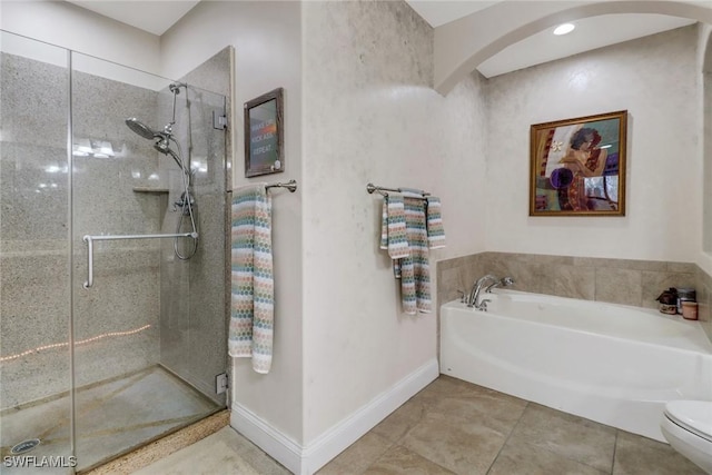 full bathroom featuring a stall shower, baseboards, toilet, tile patterned flooring, and a bath