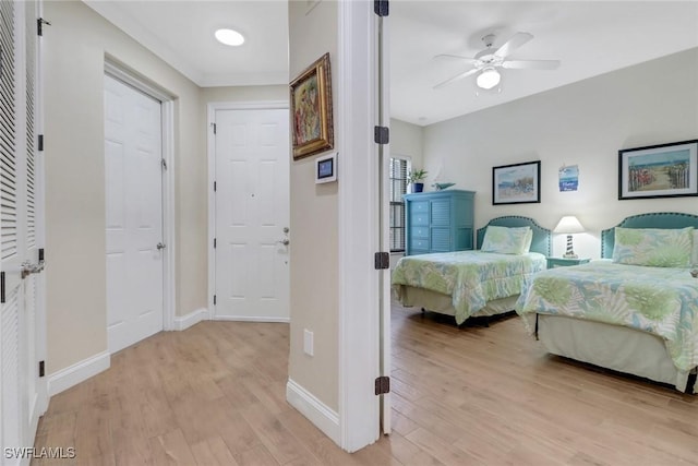 bedroom with ceiling fan, light wood finished floors, and baseboards