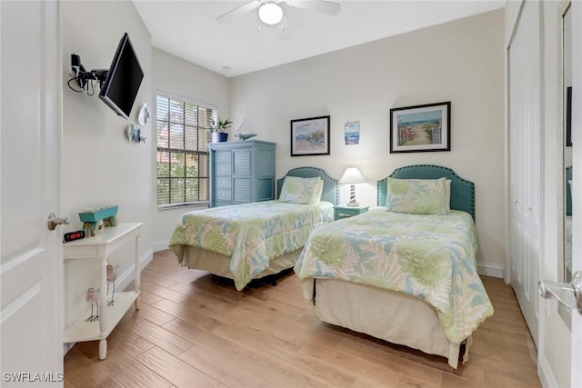 bedroom featuring light wood-type flooring, baseboards, and a ceiling fan