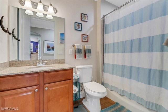 bathroom featuring curtained shower, vanity, and toilet