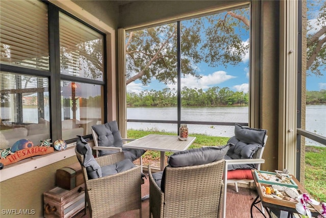 sunroom / solarium featuring a water view