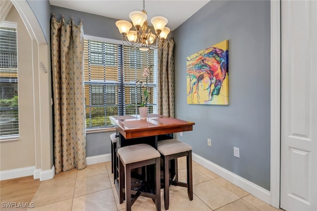 1296 Verde Dr Unit 3, Naples, FL 34105 - dining area with a chandelier, baseboards, arched walkways, and light tile patterned flooring