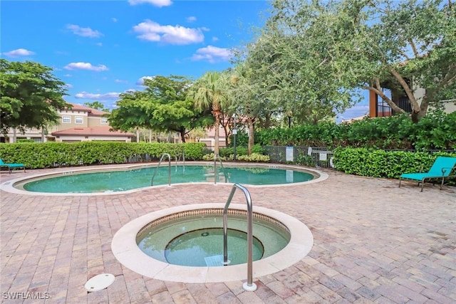 community pool with a community hot tub, a patio area, and fence