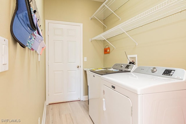 laundry room featuring light wood-type flooring and washing machine and clothes dryer