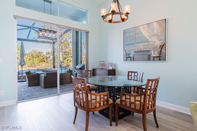 dining area with hardwood / wood-style flooring and an inviting chandelier