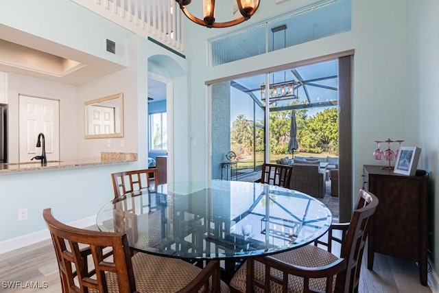 dining room featuring hardwood / wood-style flooring, sink, and a chandelier