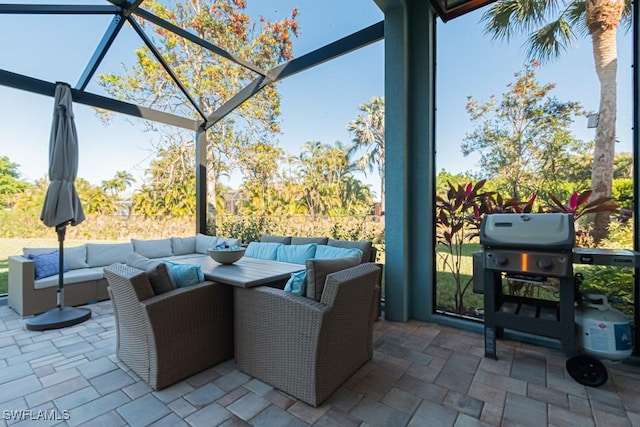 view of patio / terrace featuring glass enclosure, outdoor lounge area, and a grill